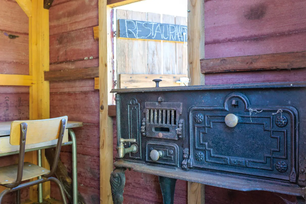 Intérieur de la cabane de jeux des enfants, vieux poêle et banc d'écolier