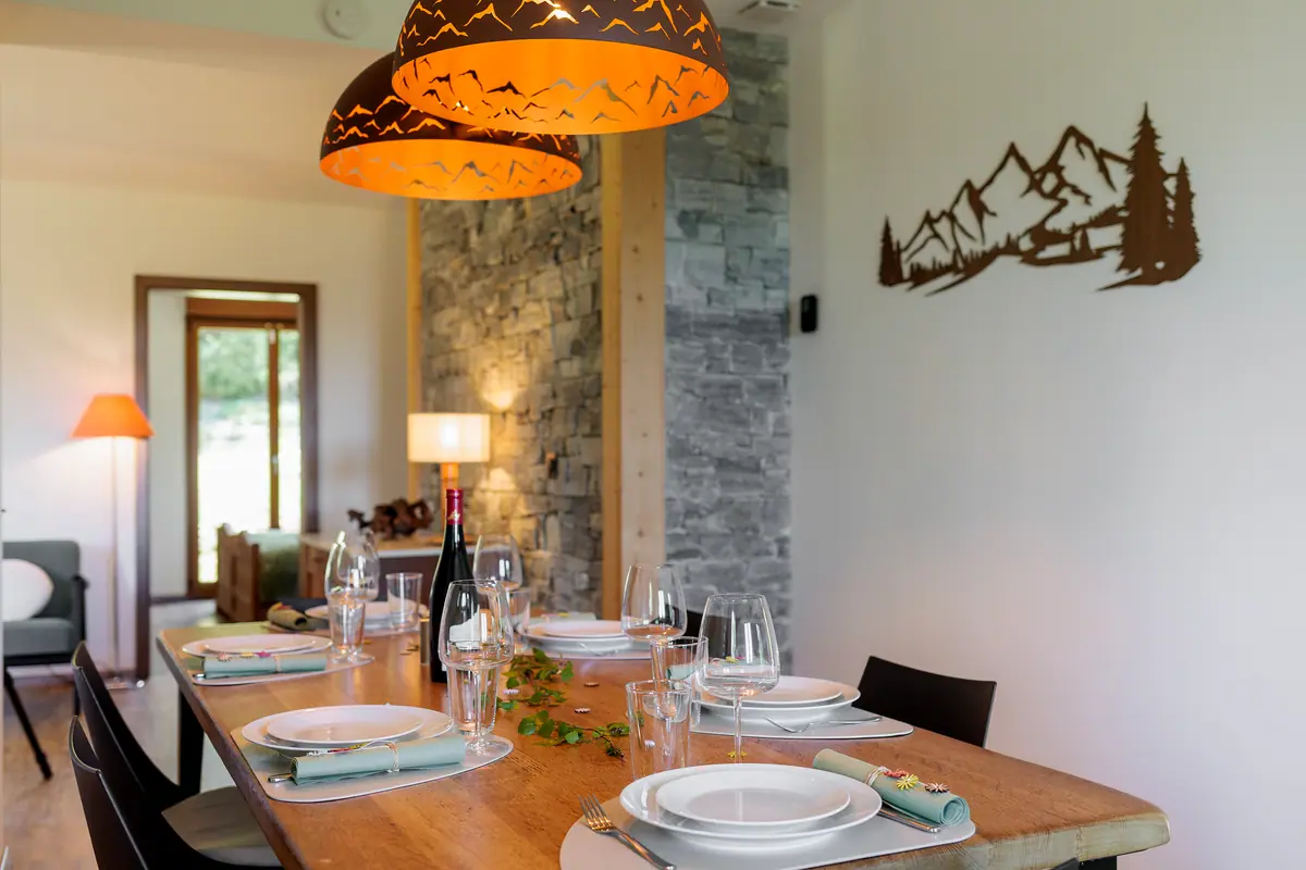 Salle à manger du chalet, table dressée sous les suspensions ligne de crête