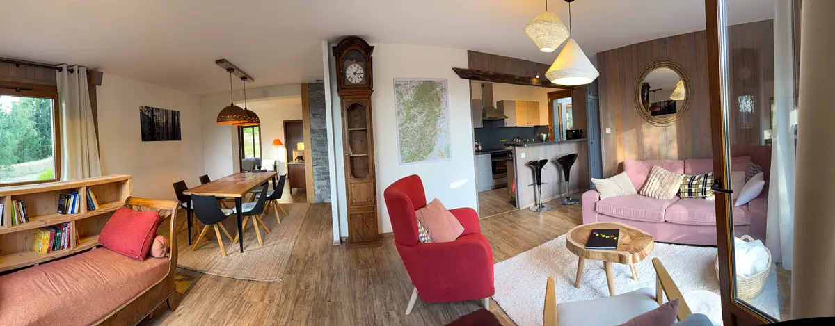 Vue panoramique du grand séjour du chalet, du salon à la salle à manger